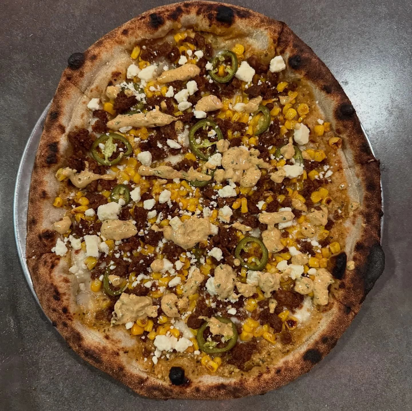 ELOTE sauce, mozzarella, corn, chorizo, pickled jalapeño, cotija cheese.