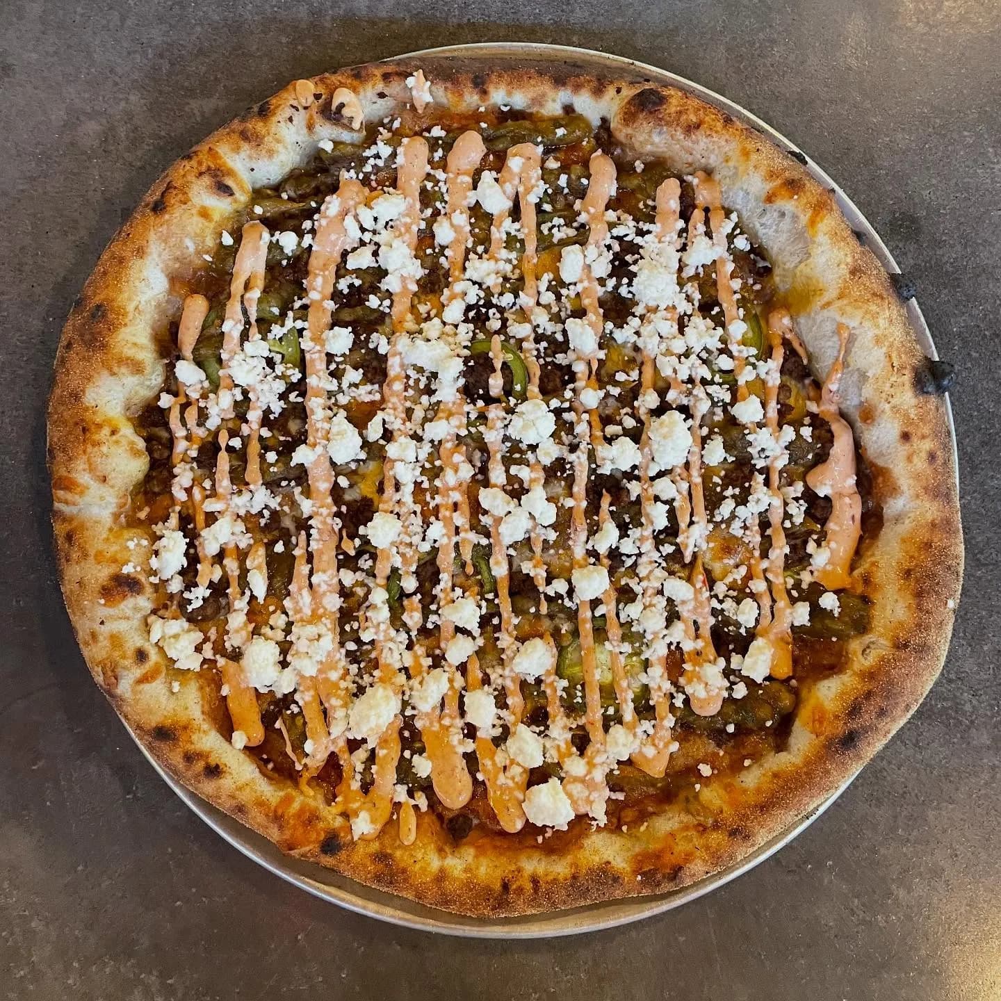Refried beans, Mexican cheese blend, ground beef, pickled jalapeño, roasted tomato salsa, chipotle cream sauce, cotija cheese.