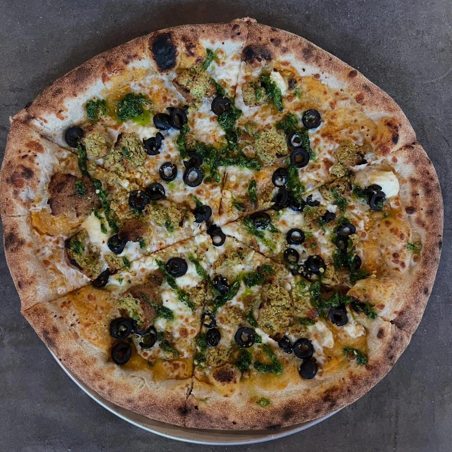 Pretty stoked on this one. Roasted red pepper hummus, feta, mozzarella, falafel, black olives, spicy zhug sauce.